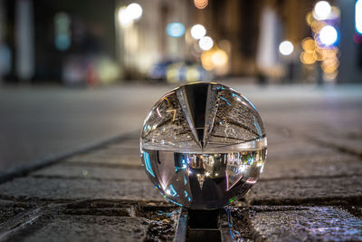 Close-up of illuminated crystal ball on street at night