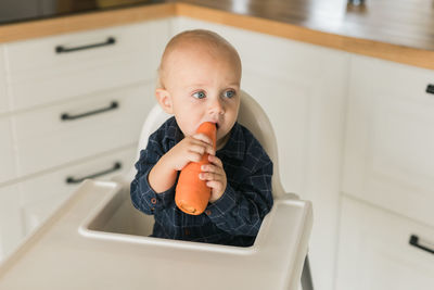 Portrait of boy eating food at home