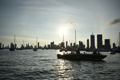 Boats in river with city in background
