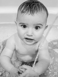 Black and white high angle view of cute baby boy in bathtub 