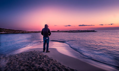 Full length of man standing on beach during sunset