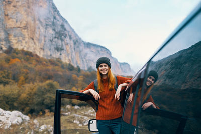 Portrait of smiling young woman standing on mountain