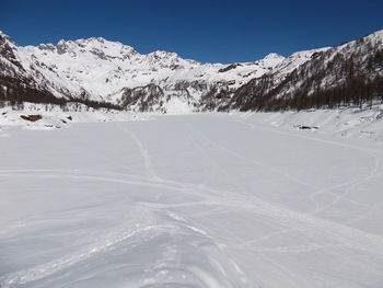 Scenic view of snow covered mountains against clear sky