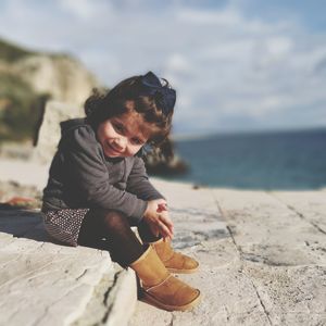 Portrait of girl on beach against sky