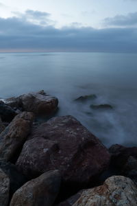 Rocks on sea shore against sky