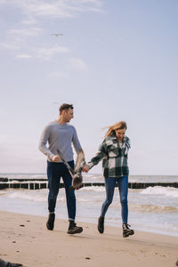 Close up of couple walking near the sea and looking to each other.