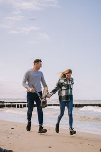 Full length of woman on beach against sky