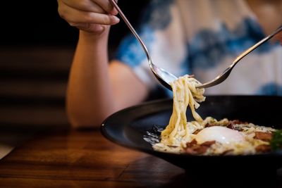 Close-up of hand holding ice cream on table