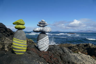 Stack of rocks on beach against sky