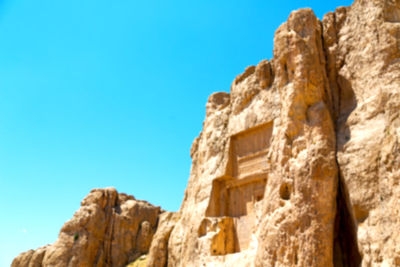 Low angle view of rock formation against clear blue sky