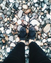 Low section of person standing on pebbles