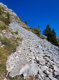Low angle view of rocks against blue sky