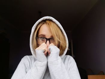 Portrait of young woman wearing hooded shirt at home