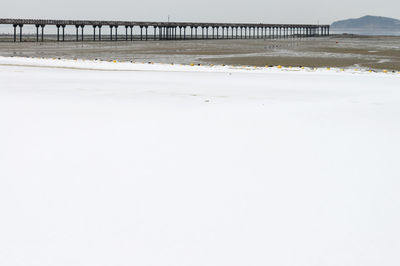 Bridge over sea against sky during winter