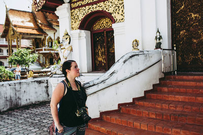 Full length of woman standing on staircase against building