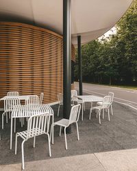 Empty chairs and table against trees