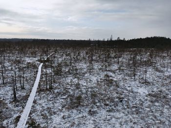 Scenic view of snow covered field against sky