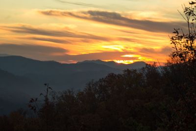 Scenic view of silhouette mountains against sky at sunset