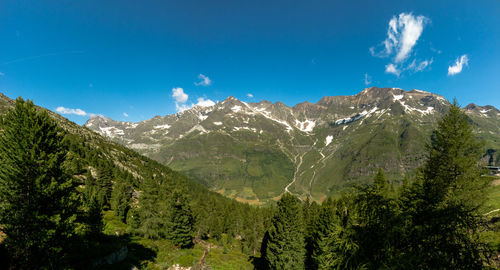 Panoramic view of landscape and mountains against blue sky