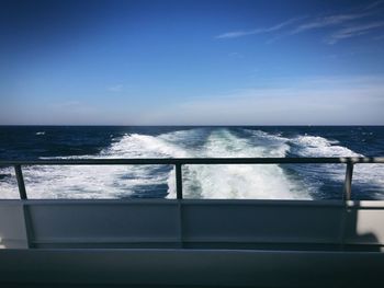 Boat sailing in sea against blue sky