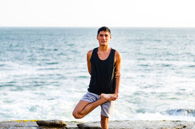 Man standing at beach against sky