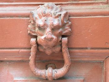 Close-up of rusty statue against wall