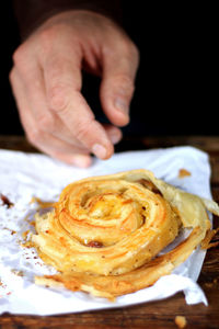 Close-up of hand reaching for pastry