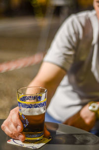 Midsection of man holding beer glass