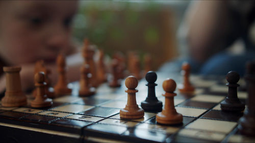 Defocused image of girl playing chess