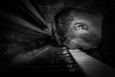 Close-up of tired pianist leaning on piano