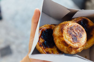 Cropped image of hand holding food in box