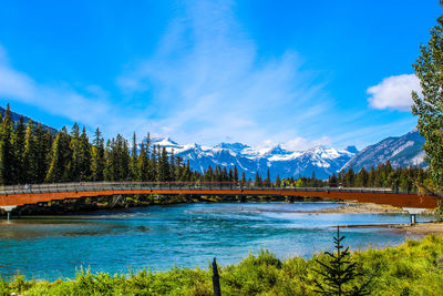 Scenic view of lake and mountains against blue sky