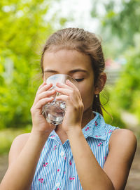 Front view of girl drinking water from glass