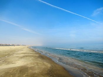 Scenic view of beach against blue sky