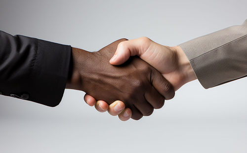 Cropped hand of man holding hands against white background