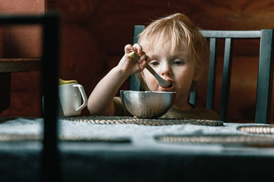 Portrait of cute baby girl in bowl on table