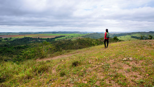 Rear view of woman looking at landscape against sky