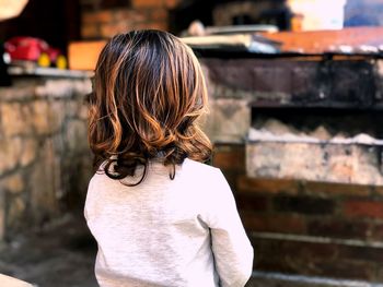 Rear view of woman standing against wall