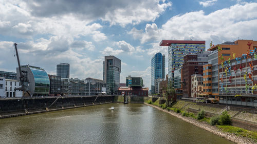 Buildings in city against cloudy sky