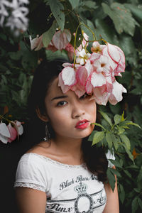 Close-up portrait of woman with pink flower