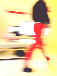 Blurred motion of woman walking in city