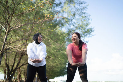 Rear view of couple standing against trees