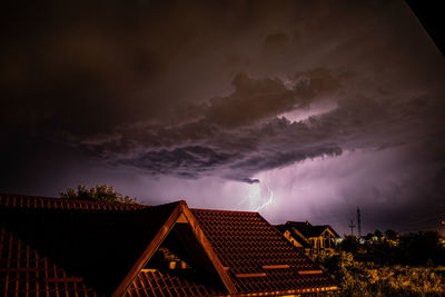 Low angle view of houses against dramatic sky