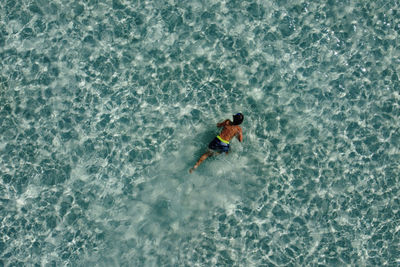 Little kid snorkeling on a turquoise ocean. aerial view