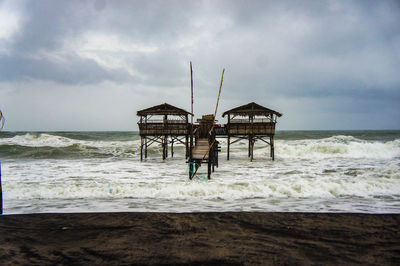 Lifeguard hut on beach against sky