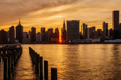 Modern buildings in city against sky during sunset