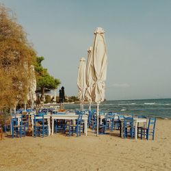 Chairs on beach against clear sky