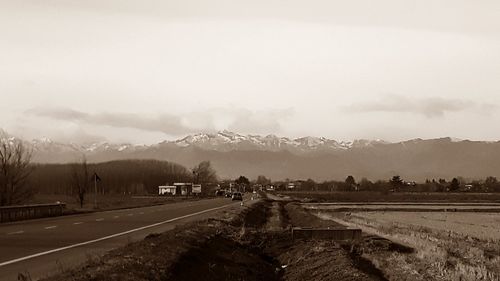 Road leading towards mountain against sky