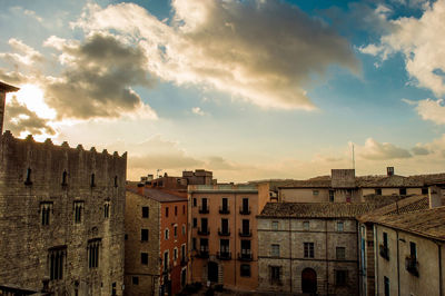 Buildings in town against sky during sunset