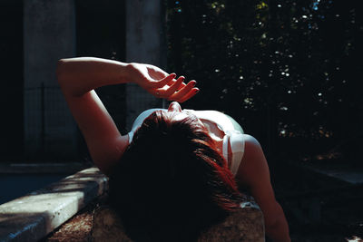 Rear view of woman with arms raised in park